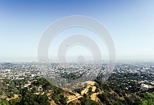 Panoramic view of LA downtown and suburbs from the beautiful Griffith Observatory in Los Angeles, helicopter flying above the city
