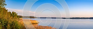 Panoramic view of lake coast on sunrise in spring