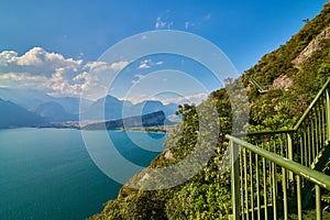 Panoramic view on Lake Garda from the Busatte-Tempesta trail near Nago-Torbole with the iron staircase,  Torbole  town surrounded