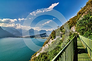 Panoramic view on Lake Garda from the Busatte-Tempesta trail near Nago-Torbole with the iron staircase,  Torbole  town surrounded photo