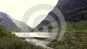 Panoramic view of a lake between hills on a windy day in Glencoe Valley, Isle of Skye, Scotland