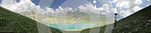 panoramic view of lake and mountain.mountain landscape with touching clouds.boy taking photo