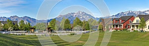 Panoramic view of a large field at the front of residential houses at Daybreak, Utah