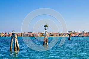 Panoramic view of Lusenzo lagoon with wooden bricole poles in water and Sottomarina town photo