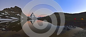 Panoramic view of the Matterhorn peak reflected in the Riffelsee.