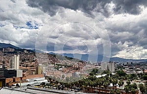 Medellin Antioquia, Colombia. Stormy sky, palm trees and brick buildings. photo