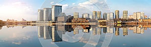 Panoramic view of modern buildings on the river bank in the Moscow district with reflections in the water