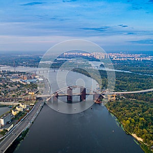 Panoramic view of a modern city with a river, unfinished bridge and park part of the city
