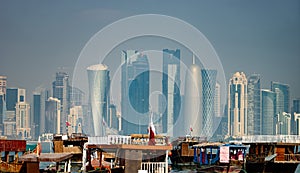 Panoramic view of modern skyline of Doha with old fishing boats foreground