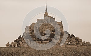 Panoramic view of Mont Saint Michel abbey in Northern France with antiqued sepia effect