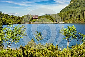 Panoramic view of the Morskie Oko mountain lake surrounding larch, pine and spruce forest with Schronisko przy Morskim Oku shelter photo