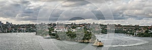 Panoramic view of the Mosman bay wharf and Cremorne Point under a dramatic cloudy sky in Sydney, Australia