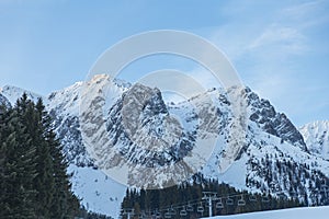 Panoramic view of mountain peaks with ski lifts at sunrise. Austria.