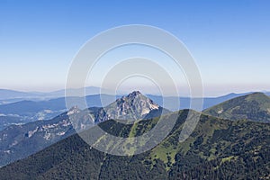 Panoramatický výhľad na pohorie. Pohľad na Malý a Veľký Rozsutec v národnom parku Malá Fatra. Modrá bezoblačná obloha.