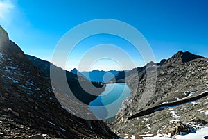 Panoramic view on the mountains of Hohe Tauern Alps in Carinthia, Austria, Europe. A lake reflection and water reservoir on the