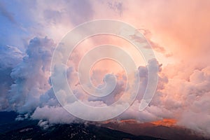 Panoramic view of the mountains in incredible clouds shot in the beautiful sunset light. Drone shot top view.