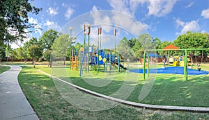 Panoramic view neighborhood playground with sun shade sails, artificial grass in Flower Mound, Texas, America