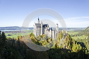 A panoramic view of Neuschwanstein Castle with trees in Bavaria Germany.