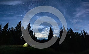 Two camp tents in forest under beautiful night sky.