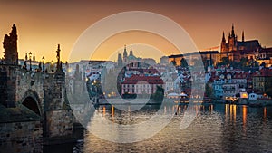 Panoramic view of night time illuminations of Prague Castle, Charles Bridge and St Vitus Cathedral reflected in the Vltava river.