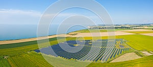 The panoramic view of Norman solar panels in the flax fields in Europe, France, Normandy, in summer on a sunny day