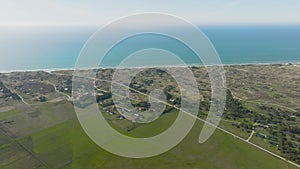 Panoramic view, north sea, summer houses built on grassy sand dunes, green meadows