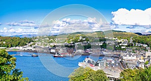 A panoramic view of Oban on the west coast of Scotland, showing the town, ferry terminals and hills in  the background, taken on a photo