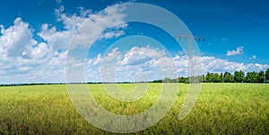 Panoramic view over beautiful green farm landscape with light and shadow waves in Germany with clouds in sky, wind turbines to