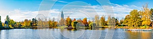 Panoramic view over city park Rotehorn and lake in Autumn colors at sunny day with blue sky, Magdeburg, Germany