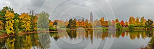 Panoramic view over city park Rotehorn and lake in Autumn golden colors at cloudy rainy day, Magdeburg, Germany