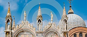 Panoramic view over decoration elements at roofs and cupolas of Basilica San Marco in Venice, Italy, at sunny day and deep blue