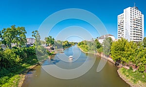 Panoramic view over Elbe river, new buildings for living and people relaxing on floating BBQ boat in Magdeburg, Germany, Summer