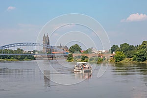 Panoramic view over old cathedral at historical downtown in Magdeburg with a touristic party boat with many girls coming by at
