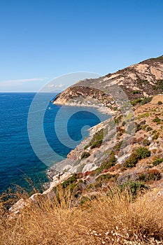 Panoramic view over rocky beach of little village Chiessi and coastal road in autumn at western Elba Island, Italy