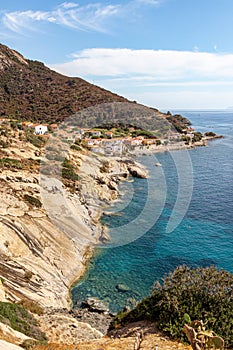Panoramic view over rocky beach of little village Pomonte and coastal road in autumn at Elba Island, Italy