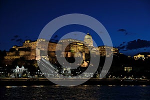 Panoramic view of the palace with illumination of walls from Danube at night.