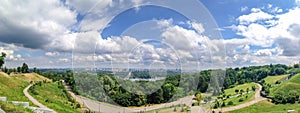 Panoramic view from the park area to the trees, grass, cloudy sky, the Dnieper River and the city of Kiev, Ukraine