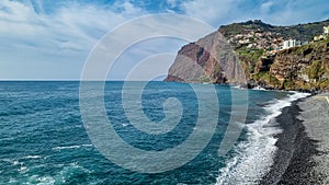 Panoramic view of Praia de Vigario in Camara de Lobos on Madeira island, Portugal, Europe. Black stone beach in Atlantic Ocean