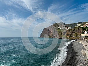 Panoramic view of Praia de Vigario in Camara de Lobos on Madeira island, Portugal, Europe. Black stone beach in Atlantic Ocean