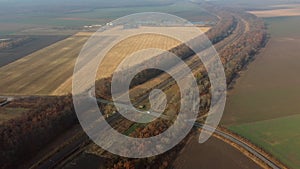Panoramic View of Railroad Crossing Between Trees in Fields on Autumn Day