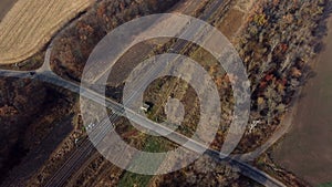 Panoramic View of Railroad Crossing Between Trees Fields Autumn Day Aerial Drone