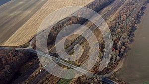 Panoramic View of Railroad Crossing Between Trees Fields Autumn Day Aerial Drone