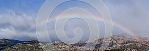 Panoramic view of the rainbow over La Pedriza.