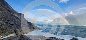 Panoramic view of the rainbow over Niagara Falls, Ontario, Canada on a sunny day