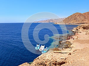 Panoramic view of the Red Sea coast with fishing boat and Desert mountain. Extreme landscapes