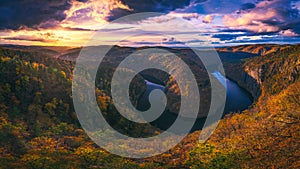 Panoramic view of river canyon with dark water and autumn colorful forest. Horseshoe bend, Vltava river, Czech republic.