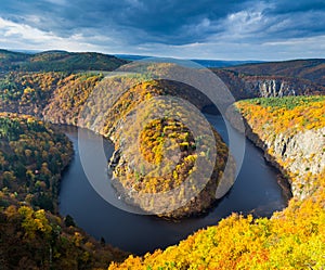 Panoramic view of river canyon with dark water and autumn colorful forest. Horseshoe bend, Vltava river, Czech republic. Beautiful