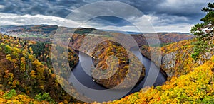 Panoramic view of river canyon with dark water and autumn colorful forest. Horseshoe bend, Vltava river, Czech republic. Beautiful