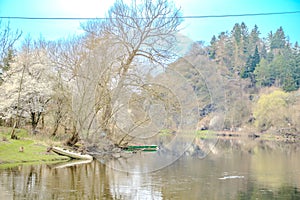 Panoramic view of river with emerald water and boats in the early spring