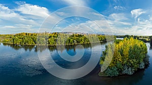 Panoramic view of a river valley in autumn. The yellow tone is observed in the vegetation it makes contrast with the river and the